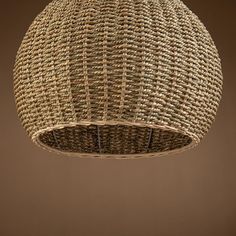 a wicker lamp hanging from the ceiling in a room with brown walls and flooring