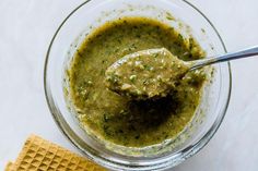 a spoon in a bowl filled with pesto