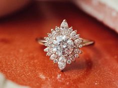 a diamond ring sitting on top of an orange surface