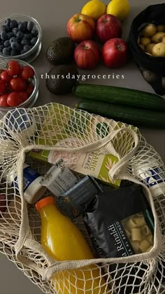 a bag full of food sitting on top of a table next to other fruits and vegetables