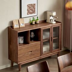 a dining room table with chairs and a wooden cabinet in front of a window that has pictures on it