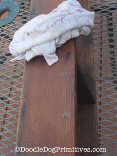 a cloth wrapped around the edge of a wooden bench with metal grate behind it