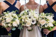 three bridesmaids holding bouquets of white and blue flowers