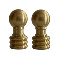 two brass colored knobs are shown against a white background