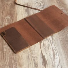 a brown leather case sitting on top of a wooden table