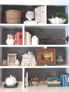 a white book shelf filled with lots of books and knick - knacks