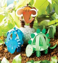 some paper animals are sitting in the dirt