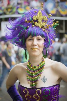 a woman with purple hair and green jewelry