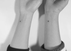 two small tattoos on the wrist are shown in this black - and - white photo