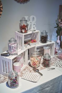 a table topped with lots of jars filled with candies and other candy items on top of it