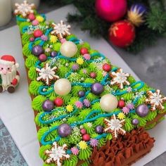 a decorated christmas tree shaped cake next to a small figurine