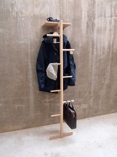 a coat rack with two coats hanging from it's sides next to a wall