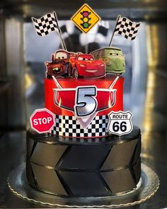 a birthday cake with cars on top and number 5 in the middle is decorated to look like a race car