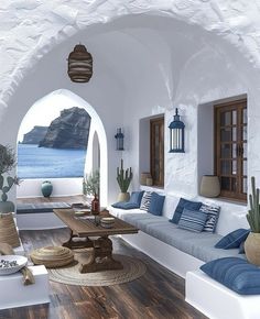 a living room with white walls and wood flooring next to an arch in the wall