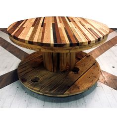 a table made out of pallet boards on top of a wooden stand in the middle of a floor