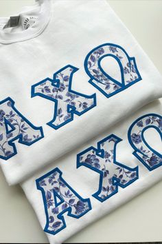 two white shirts with blue letters on them