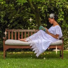 a woman sitting on a bench reading a book