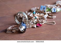 many different rings and necklaces on a wooden table