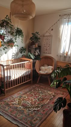 a baby crib in the corner of a room with plants on the wall and rug