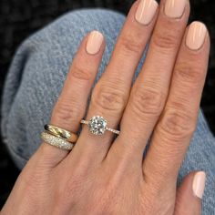 a woman's hand with two rings on her fingers and one ring in the middle