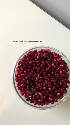 a glass bowl filled with pomegranate on top of a table