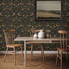 a dining room table with two chairs and a vase on the table in front of it