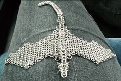 a silver chain is attached to the back of a person's jeans with an intricate design on it