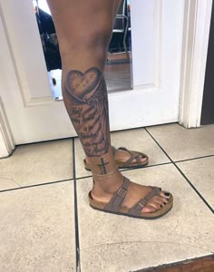 a person with a cross tattoo on their leg and foot is standing in front of a door