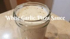 a white garlic pizza sauce in a glass jar on a counter top with the words white garlic pizza sauce above it