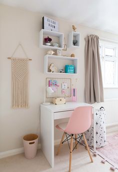 a white desk topped with a pink chair next to a window