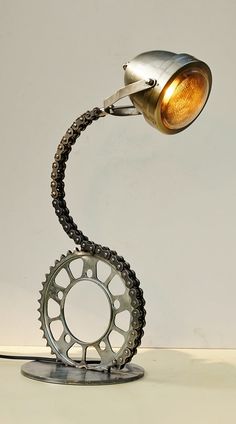 a lamp that is sitting on top of a table next to a bike chain and sprock