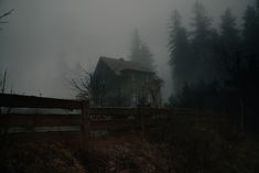 a house in the woods on a foggy day