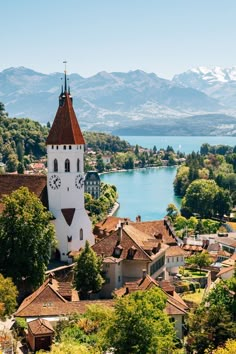 an aerial view of a town with a lake and mountains in the background