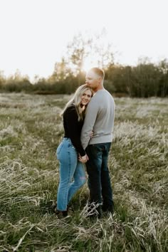 a man and woman standing in the middle of a field