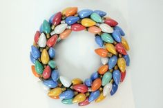 a multicolored bracelet is displayed on a white surface with an orange, yellow, and blue bead around it