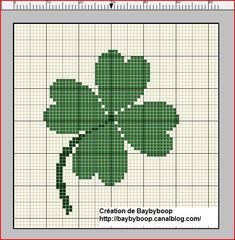 a cross stitch pattern with a green four leaf clover on it's back side