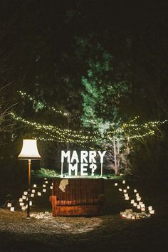 a sign that reads merry and lit up in the dark with some lights on it