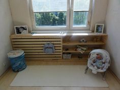 a baby's room with a large window and wooden shelves