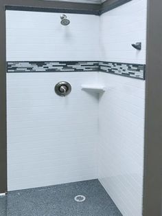 a white shower with black and gray tile on the floor, walls and ceiling in a bathroom