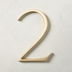 the number two is made up of wood and has been painted gold with a white background