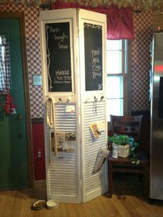 a tall white cabinet sitting in the middle of a kitchen next to a refrigerator freezer