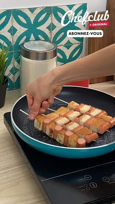 a person cutting up some food on top of a wooden table with a blue plate