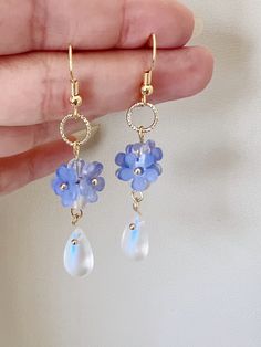 Embrace the timeless beauty of these handmade earrings adorned with delicate little blue "Forget Me Not" flowers, symbolizing love and fidelity.  Suspended from each blossom, glistening crystal drops add a touch of sparkle and allure. With their understated charm and handmade craftsmanship, they make a captivating addition to any ensemble, infusing it with grace and romance. A perfect gift for her, these earrings exude elegance, making them an exquisite choice for bridal wear or as a captivating Blue Flower Charm Drop Earrings, Blue Drop Earrings With Flower Charm, Elegant Blue Drop Earrings With Flower Charm, Blue Drop Flower Earrings With Ear Wire, Blue Flower Earrings For Jewelry Making, Blue Teardrop Bohemian Flower Earrings, Blue Drop Flower Earrings, Blue Bohemian Teardrop Flower Earrings, Bohemian Blue Teardrop Flower Earrings