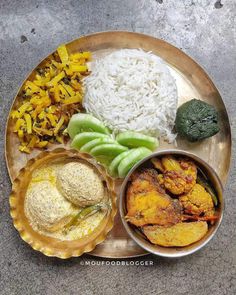 a metal plate topped with different types of food on top of a cement floored surface