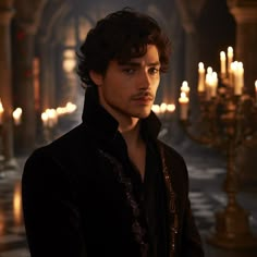 a young man standing in front of candles