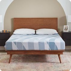 the bed is made and has two pillows on top of it, with an arch in the background