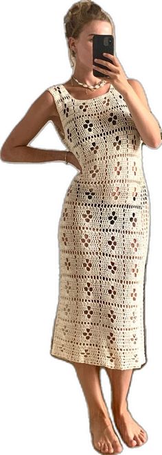 a woman is taking a selfie with her cell phone while wearing a crocheted dress