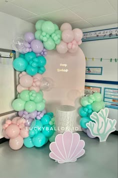 the balloon arch is decorated with pastel colors