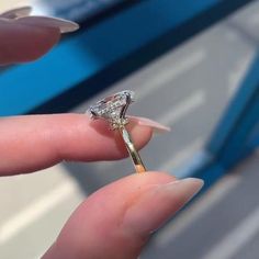 a woman's hand holding a diamond ring