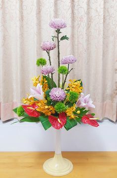 a vase filled with flowers on top of a wooden table